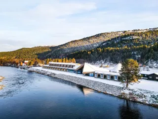 Arctic Wilderness hotell ved en elv i vinterlanskap