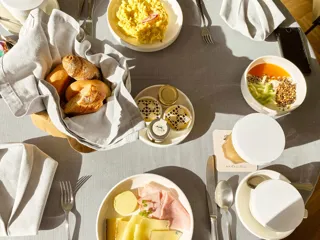 frokostbord dekket med egg, brød, ost og skinke