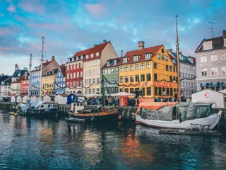 Bilde av fargerike hus og båter langs Nyhavn bryggen i København