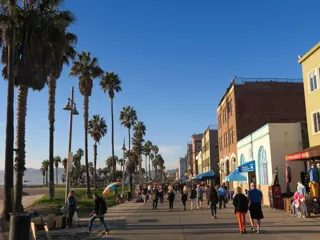 Folk som går langs promenaden ved Venice Beach i California