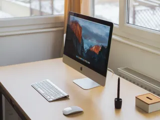 iMac med tastatur og mus på et skrivebord